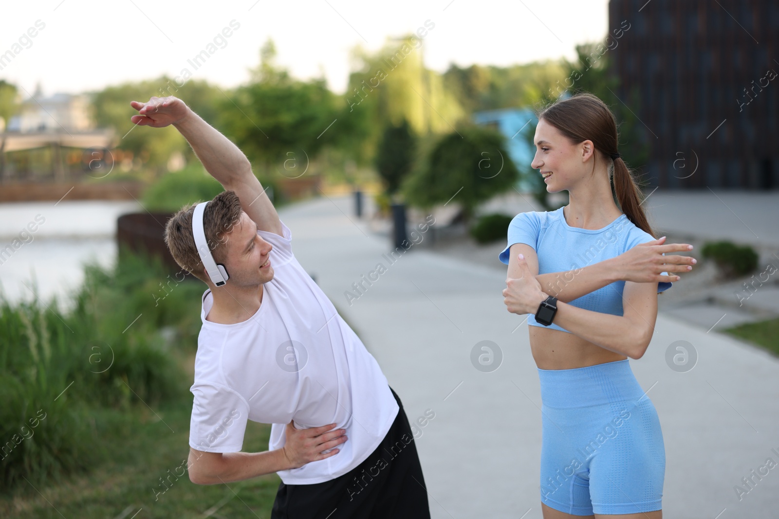 Happy couple doing morning exercises outdoors. Healthy lifestyle Photo of Happy couple doing morning exercises outdoors. Healthy lifestyle