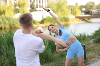 Photo of Couple doing morning exercises outdoors. Healthy lifestyle