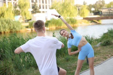 Photo of Couple doing morning exercises outdoors. Healthy lifestyle