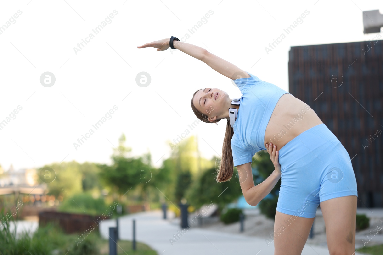 Young sportswoman doing morning exercise outdoors, low angle view with space for text. Healthy lifestyle Photo of Young sportswoman doing morning exercise outdoors, low angle view with space for text. Healthy lifestyle