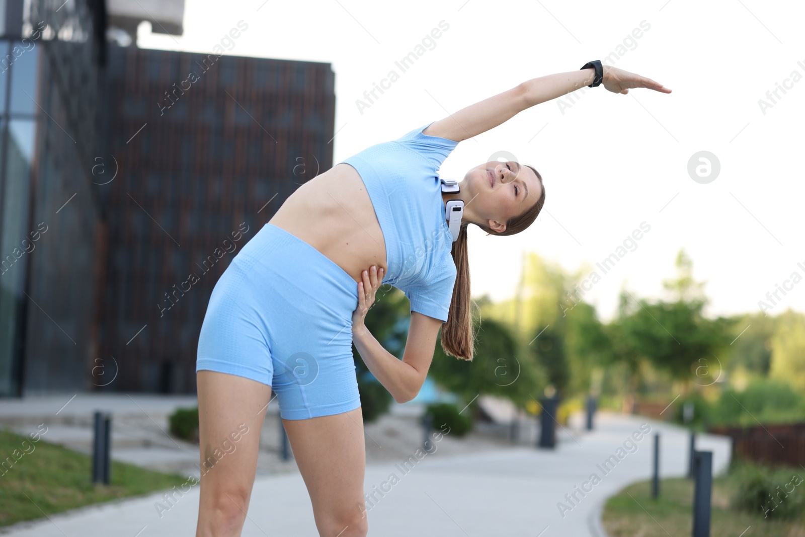 Young sportswoman doing morning exercise outdoors, low angle view. Healthy lifestyle Photo of Young sportswoman doing morning exercise outdoors, low angle view. Healthy lifestyle