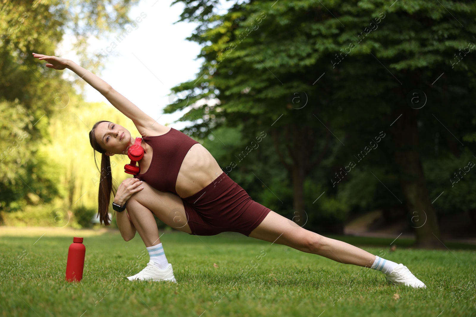 Young sportswoman doing morning exercise in park Photo of Young sportswoman doing morning exercise in park