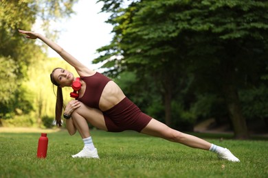 Photo of Young sportswoman doing morning exercise in park