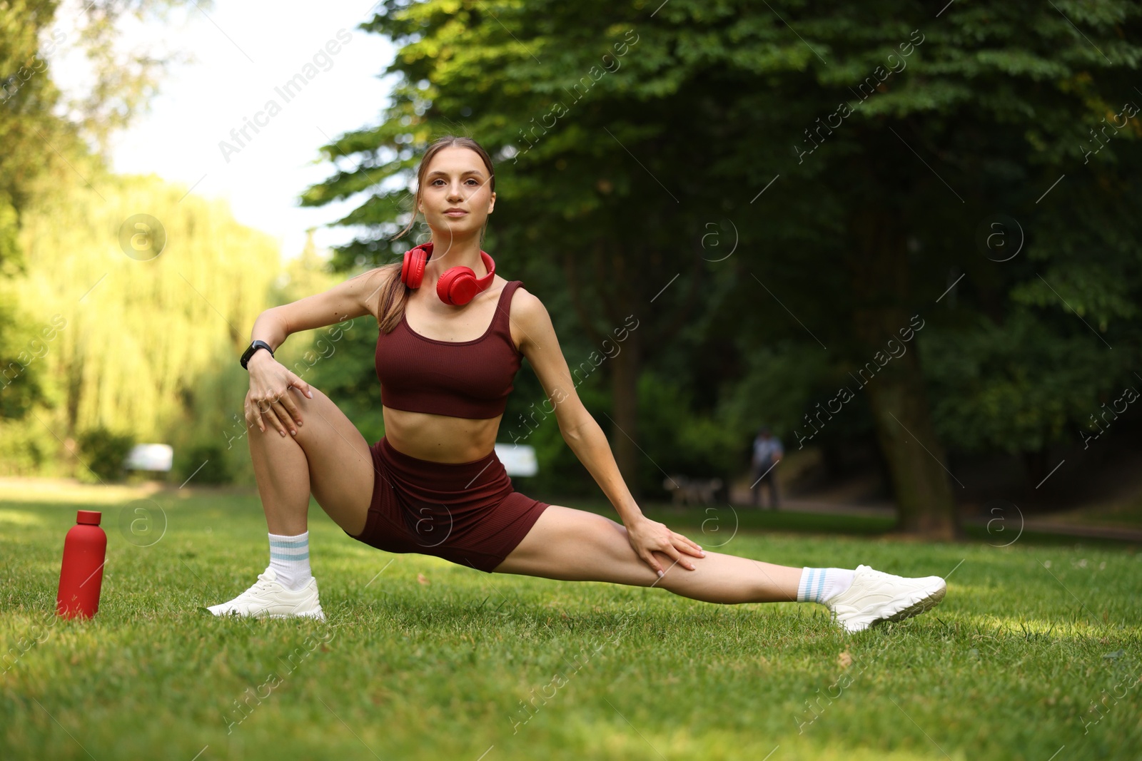 Young sportswoman doing morning exercise in park Photo of Young sportswoman doing morning exercise in park