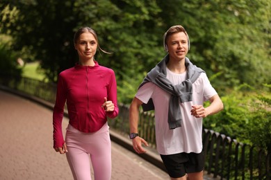 Photo of Happy couple running in park. Morning exercise