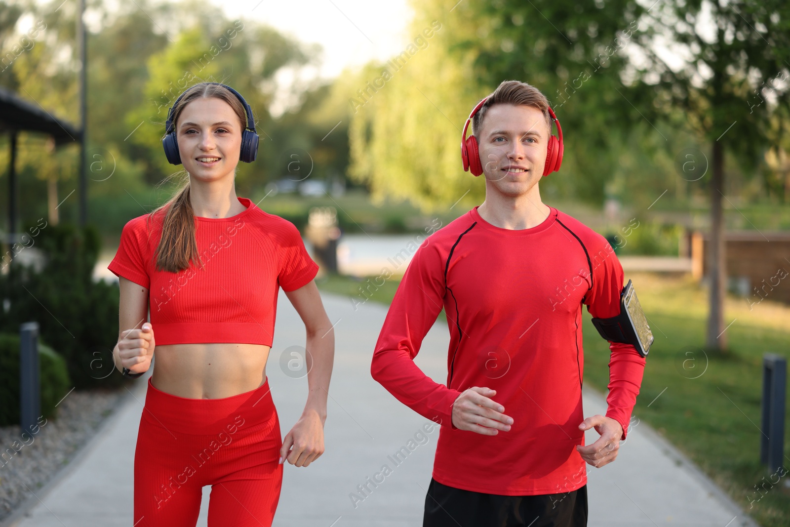 Happy couple in headphones running outdoors. Morning exercise Photo of Happy couple in headphones running outdoors. Morning exercise