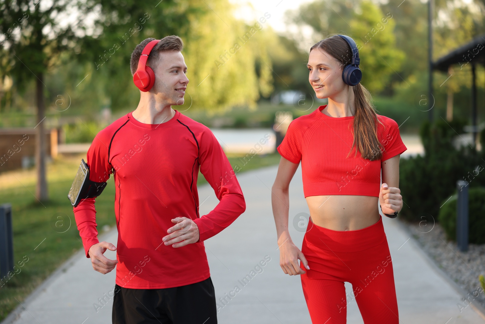 Happy couple in headphones running outdoors. Morning exercise Photo of Happy couple in headphones running outdoors. Morning exercise