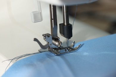 Photo of Sewing machine with thread and cloth, macro view