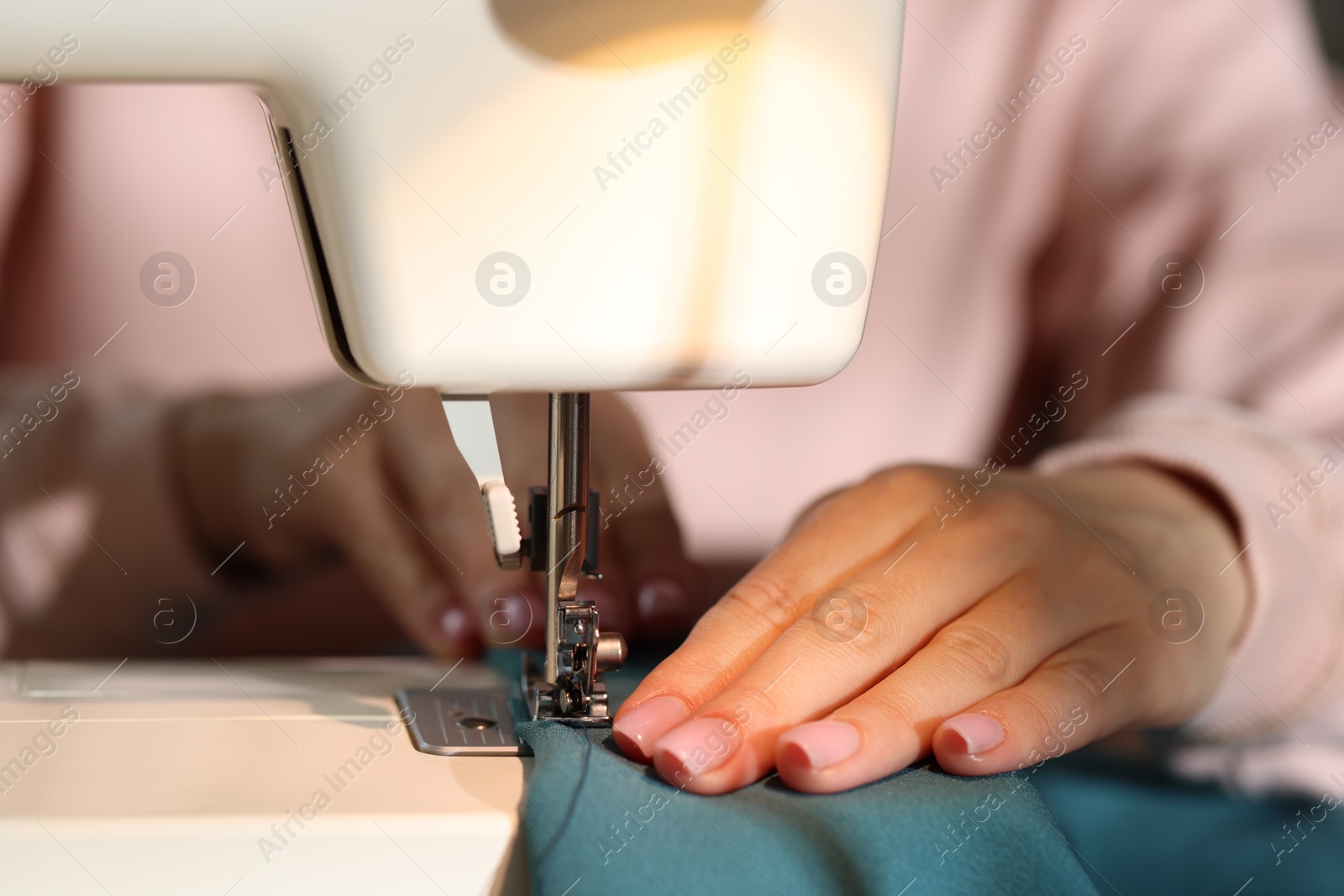 Woman working with sewing machine, closeup view Photo of Woman working with sewing machine, closeup view