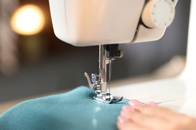 Photo of Woman working with sewing machine on blurred background, macro view
