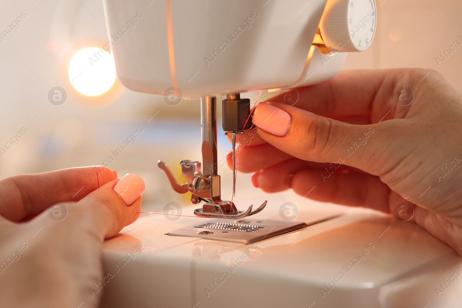 Woman working with sewing machine in workshop, closeup Photo of Woman working with sewing machine in workshop, closeup