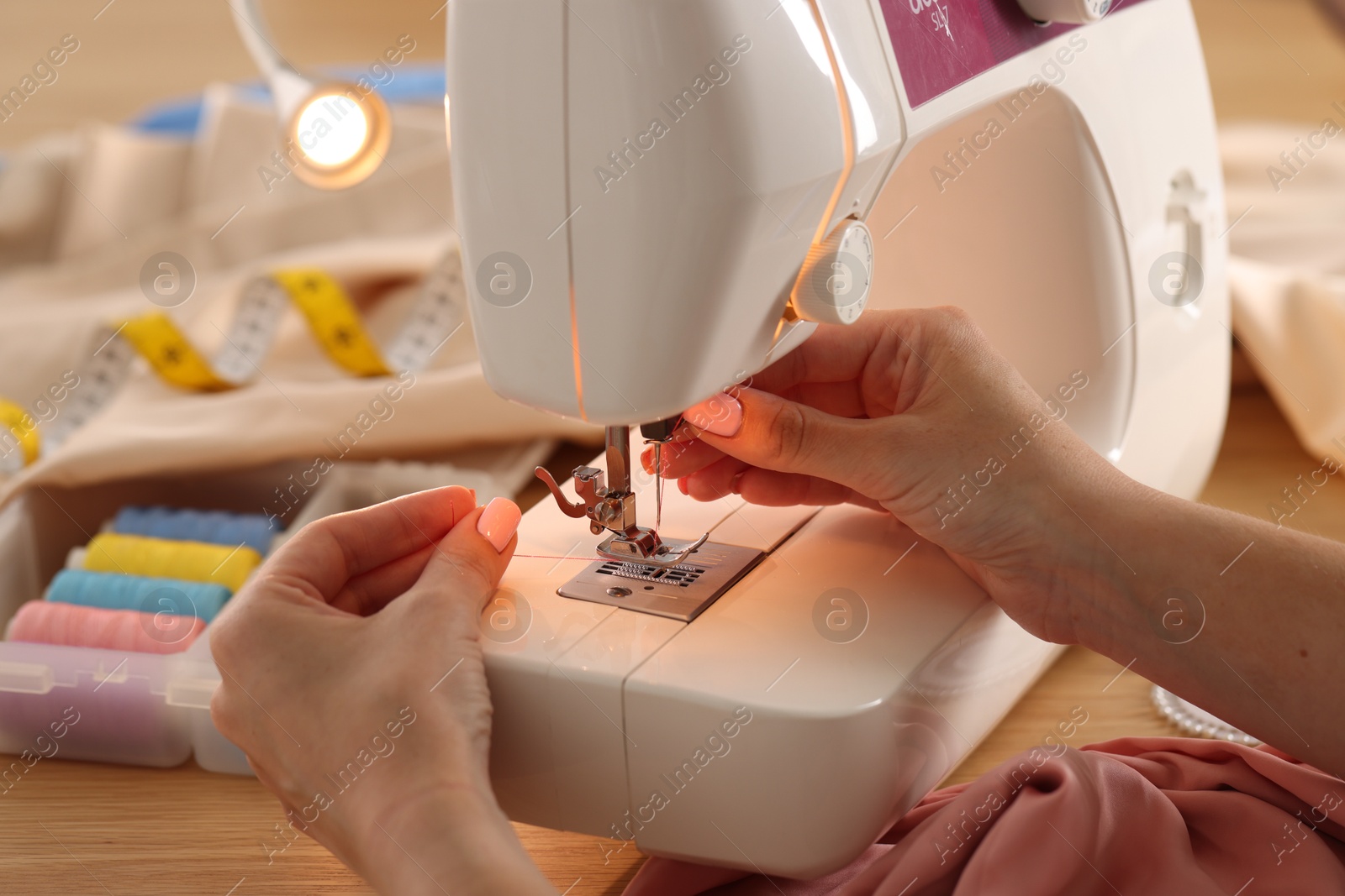 Woman working with sewing machine in workshop, closeup Photo of Woman working with sewing machine in workshop, closeup