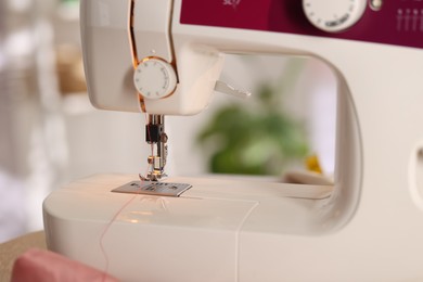 Photo of Closeup view of sewing machine with thread