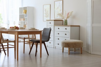 Photo of Beautiful table setting, chairs and decor in dining room. Interior design