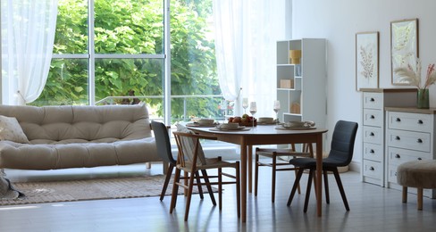 Photo of Beautiful table setting, chairs and decor in dining room. Interior design