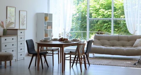 Photo of Beautiful table setting, chairs and decor in dining room. Interior design