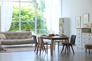 Photo of Beautiful table setting, chairs and decor in dining room. Interior design