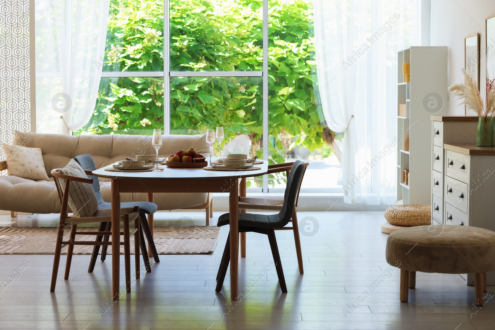 Beautiful table setting, chairs and decor in dining room. Interior design Photo of Beautiful table setting, chairs and decor in dining room. Interior design