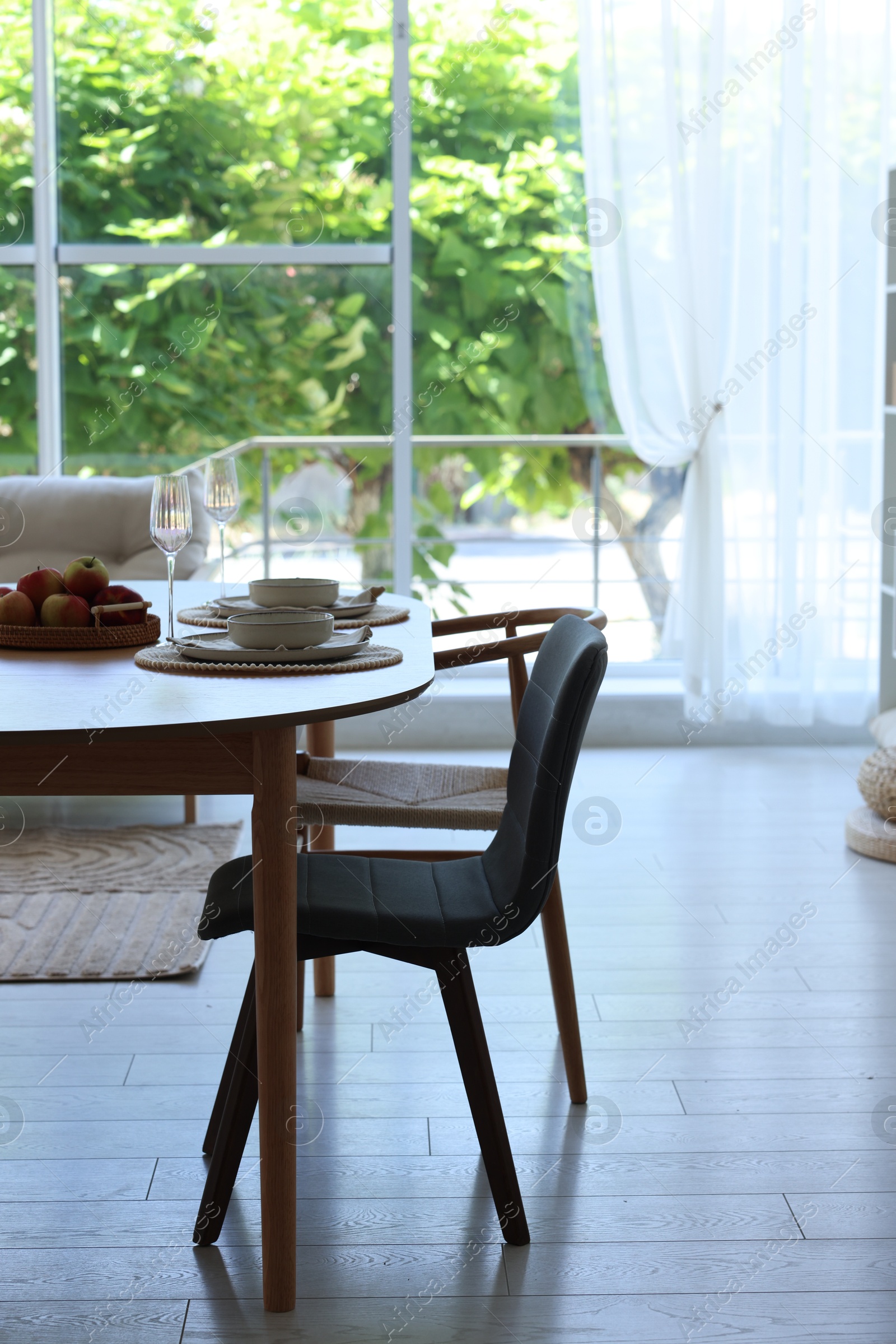Beautiful table setting, chairs and decor in dining room. Interior design Photo of Beautiful table setting, chairs and decor in dining room. Interior design
