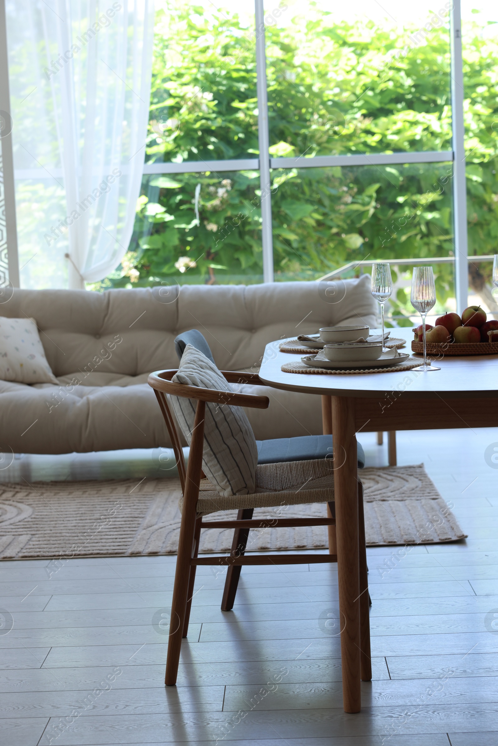 Beautiful table setting, chairs and decor in dining room. Interior design Photo of Beautiful table setting, chairs and decor in dining room. Interior design