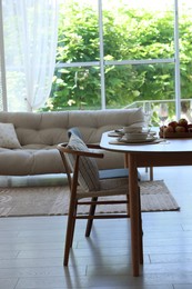 Photo of Beautiful table setting, chairs and decor in dining room. Interior design