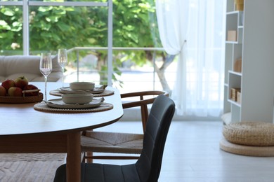 Photo of Beautiful table setting, chairs and decor in dining room. Interior design
