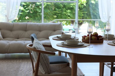 Photo of Beautiful table setting, chairs and decor in dining room. Interior design