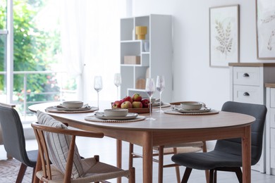 Photo of Beautiful table setting, chairs and decor in dining room. Interior design