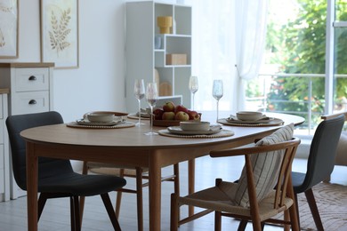 Photo of Beautiful table setting, chairs and decor in dining room. Interior design
