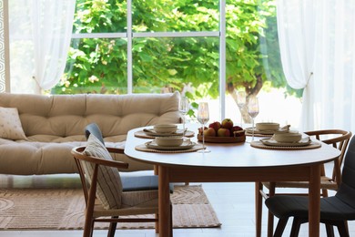 Photo of Beautiful table setting, chairs and decor in dining room. Interior design