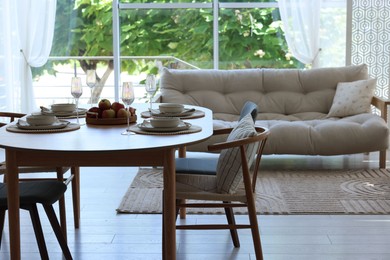 Photo of Beautiful table setting, chairs and decor in dining room. Interior design