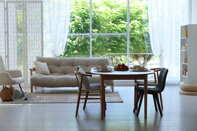 Photo of Beautiful table setting, chairs and decor in dining room. Interior design