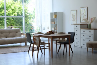 Photo of Beautiful table setting, chairs and decor in dining room. Interior design