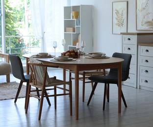 Photo of Beautiful table setting, chairs and decor in dining room. Interior design