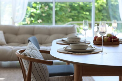 Photo of Beautiful table setting, chairs and decor in dining room. Interior design