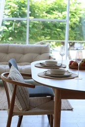 Photo of Beautiful table setting, chairs and decor in dining room. Interior design