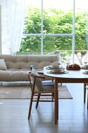Photo of Beautiful table setting, chairs and decor in dining room. Interior design