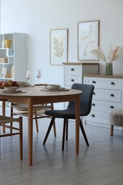 Photo of Beautiful table setting, chairs and decor in dining room. Interior design