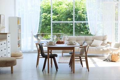 Photo of Beautiful table setting, chairs and decor in dining room. Interior design