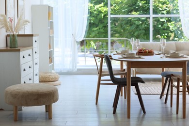 Photo of Beautiful table setting, chairs and decor in dining room. Interior design