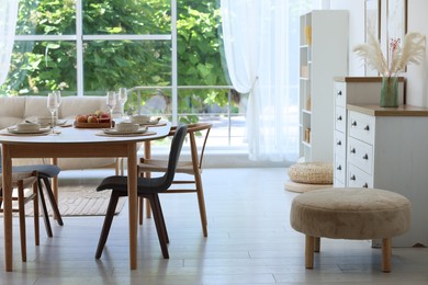 Photo of Beautiful table setting, chairs and decor in dining room. Interior design