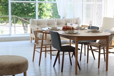 Photo of Beautiful table setting, chairs and decor in dining room. Interior design
