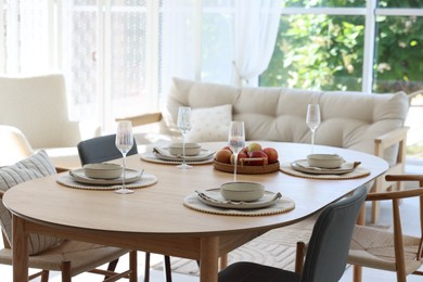 Photo of Beautiful table setting, chairs and decor in dining room. Interior design