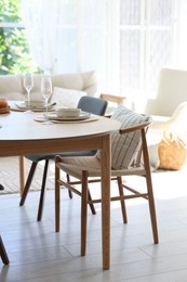 Photo of Beautiful table setting, chairs and decor in dining room. Interior design