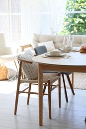 Photo of Beautiful table setting, chairs and decor in dining room. Interior design