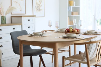 Photo of Beautiful table setting, chairs and decor in dining room. Interior design