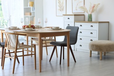 Photo of Beautiful table setting, chairs and decor in dining room. Interior design