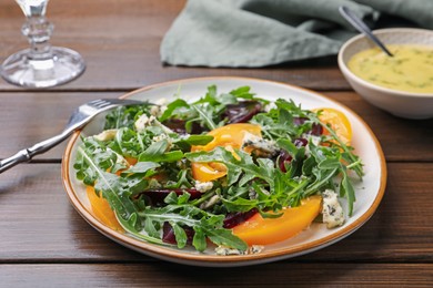 Photo of Tasty salad with arugula, blue cheese and vegetables on wooden table, closeup