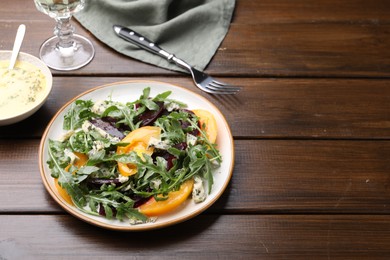 Photo of Tasty salad with arugula, blue cheese and vegetables on wooden table. Space for text