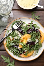Photo of Tasty salad with arugula, blue cheese and vegetables on wooden table, flat lay